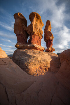 View of the unique red rock hoodoos and sandstone formations in the desert landscape under a blue sky with wispy clouds in Escalante, Utah, United States.