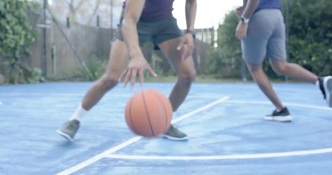 Male duo defender taking stance handler using crossovers dribbling ball creating room on blue court