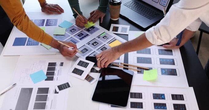 Design team collaborating on user experience and interface development, prototyping mobile application layouts