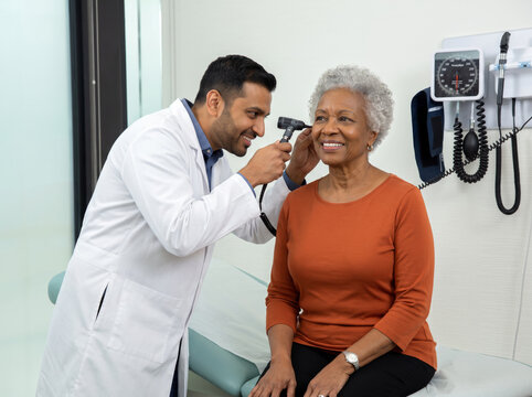 Doctor checking the ear to a senior patient.