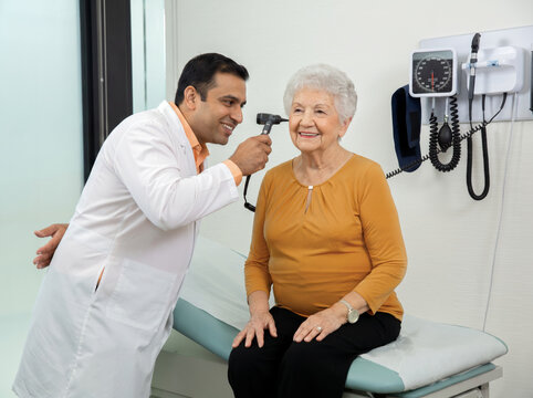 Doctor and checking ear to patient. 