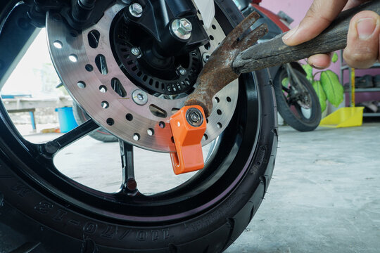 ​Motorcycle Theft Attempt with Hammer Hitting Disc Brake Lock for Security Test and Protection Concept