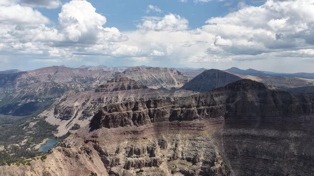 Aerial of Uinta Wasatch Cache National Forest canyons and rugged mountain ranges with deep layered rock formations and multiple lakes in the valleys in Utah in summer