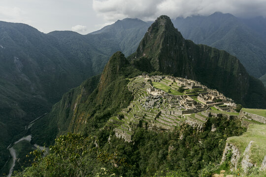View of the ancient Incan citadel of the Historic Sanctuary of Machu Picchu set amidst lush green mountain peaks and steep terraces in Urubamba Province, Cusco, Peru.