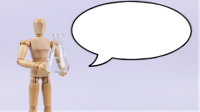 Wooden figure holds beaker, speech bubble beside it suggests scientific discussion or idea sharing.