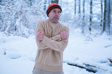 Young man in beanie and sweater shivers in snowy forest, looking lost and cold, survival struggle, winter danger, hypothermia risk, urgency rescue, Frozen and alone, freezing outdoors, lost person
