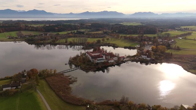 Kloster Seeon im Morgenlicht ein Ort der Ruhe und Geschichte mitten in Bayern. Aerial view of Seeon Abbey reflecting on calm water in Upper Bavaria, Germany. Seeon-Seebruck, Oberbayern, Deutschland