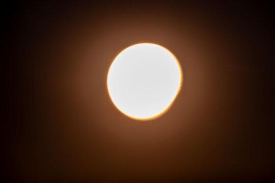 blurred partial solar eclipse glowing in dark sky, astronomical phenomenon, celestial alignment, moon crossing sun disc, stellar event, space science observation, Ghost cosmic mystery, orbital motion
