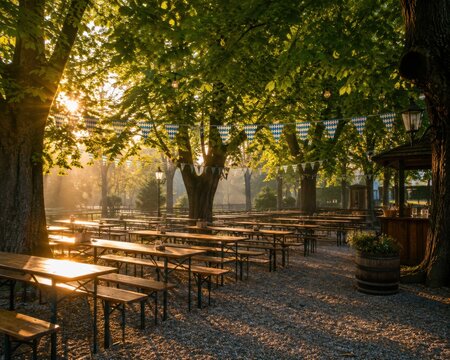 Sunlit outdoor caf&eacute; seating with wooden tables and benches in a leafy park