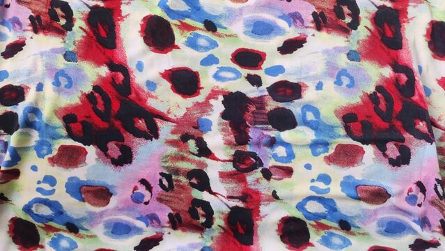 Abstract colorful leopard print pattern with red blue and black spots on white background