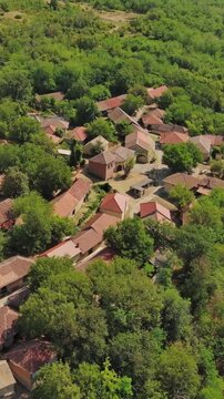 Aerial around view of old rustic vintage houses with wine cellars in Rogljevacke pivnice in Negotin region of Serbia. Vertical video 4k