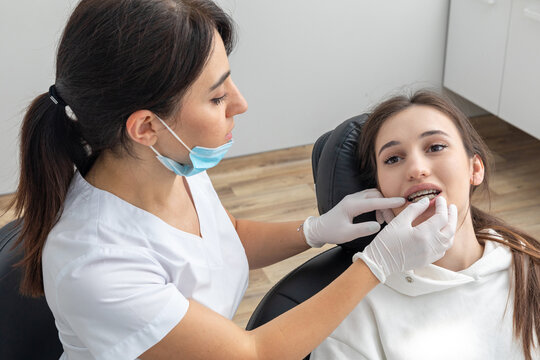 Orthodontist checking brackets on female teeth. Concept of stomatology, dentistry, orthodontic treatment of braces