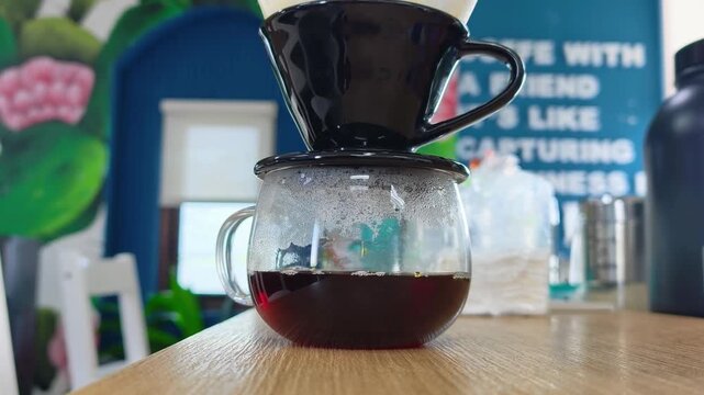 Fresh Coffee Dripping Through V60 Filter into Glass Server in Modern Cafe