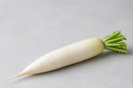 Minimal white daikon radish on matte gray surface