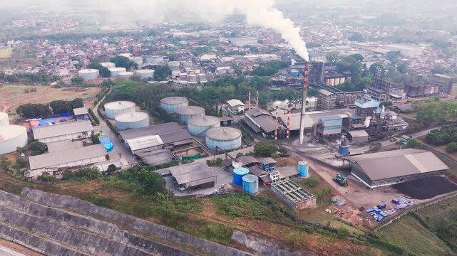 Aerial drone view of an industrial fuel storage terminal in Indonesia, featuring large storage tanks, pipelines, loading facilities, and supporting infrastructure for petroleum products and energy dis