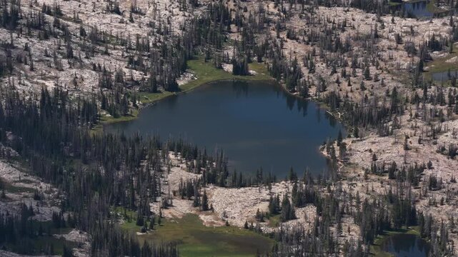 Aerial of high alpine lake and rocky terrain in Uinta Wasatch Cache National Forest in Utah in summer