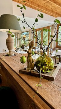 Gem&uuml;tliche Holzkommode mit Zimmerpflanzen Glasvasen und nat&uuml;rlicher Osterdekoration