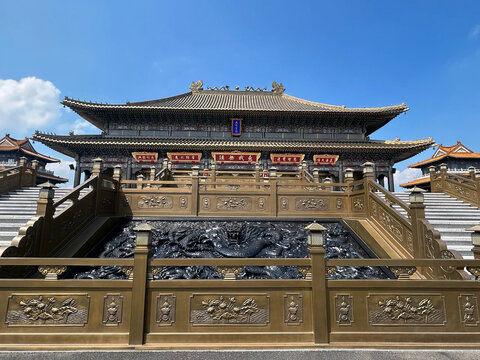 Leshan, Sichuan, China - 08 August 2026: View of Jinding Golden Summit with its ornate bronze architecture, intricate dragon carvings, and traditional roof design under a clear blue sky.