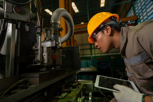 Engineering technician worker is operating the machine inside factory using touch screen computer monitor to command order for line production and steel industry