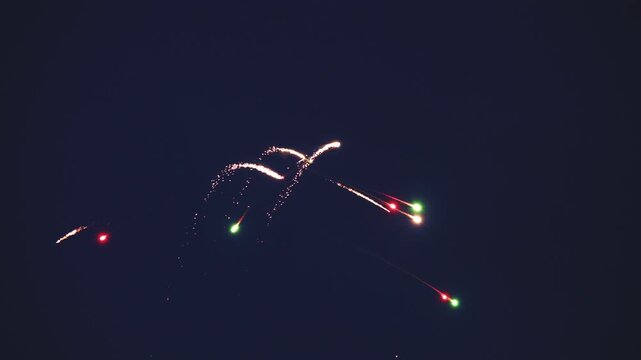 A glider performs aerobatics at night while trailing sparks.