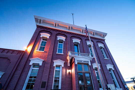 Eureka, Nevada, United States - 11 March 2026: View of the historic Eureka Courthouse with its red brick facade and white trim under a clear blue evening sky.
