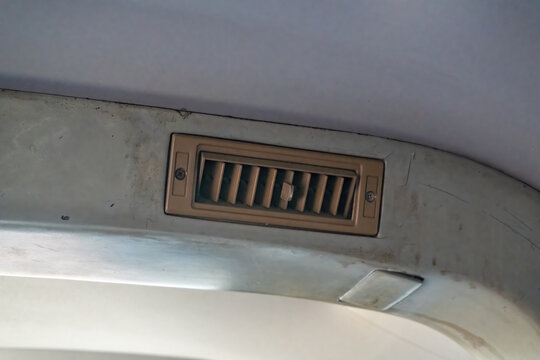 Close up of a classic car ceiling air conditioner vent and blower louver, highlighting retro vehicle climate control, ventilation systems, and interior details.