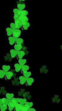Vertical video showing many shamrock leaves flying upward on a black background, designed for engaging social media content with festive energy and charm.