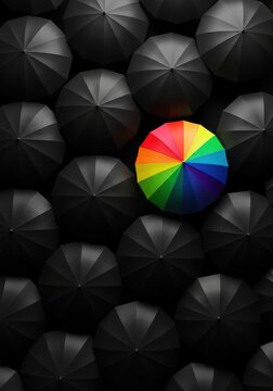 Unique Rainbow Umbrella Standing Out from a Crowd of Black Umbrellas - Concept of Individuality and Leadership