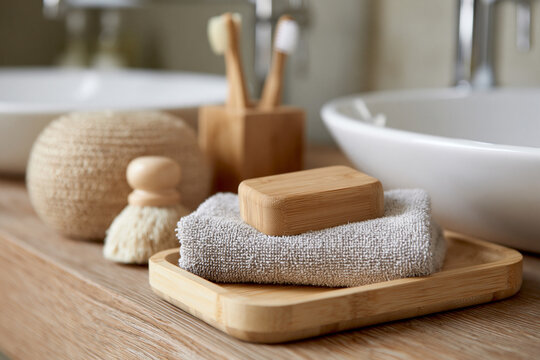 Cozy bathroom scene with bamboo and wooden accents. Natural soap rests on soft towel beside wooden tray. Minimalist design evokes calm, clean, and wellness. Ideal for health, spa