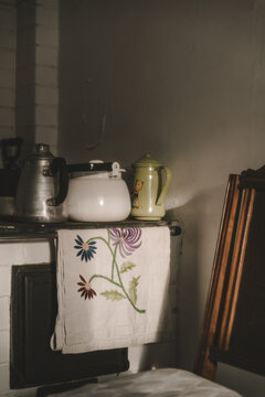 Laane County, Estonia - 25 May 2023: View of traditional kitchen items including teapots and an embroidered cloth on a stove in Vormsi.