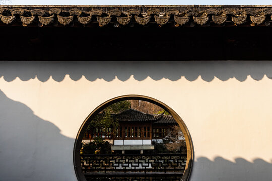 Chinese courtyard wall with moon gate and shadow pattern