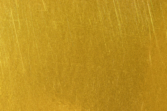 Golden texture background. Yellow metal sheet with traces of use.