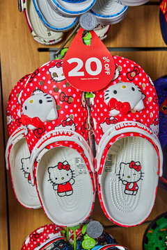 Ambato, Ecuador - November 07, 2025: Red Hello Kitty themed clogs with polka dots on display in a retail store, featuring a 20% off sale tag