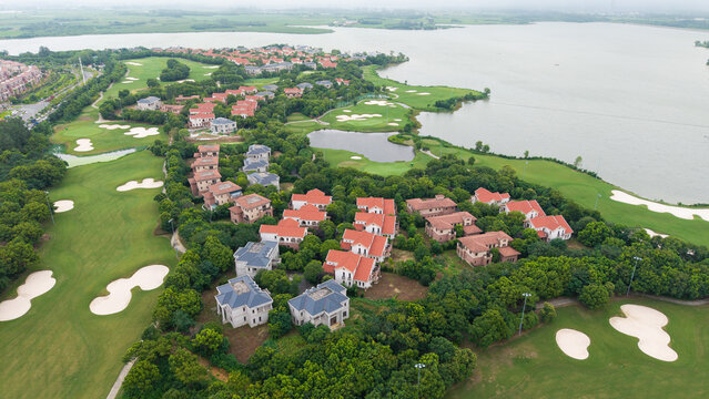 Aerial view of lakeside villa community adjacent to golf‑course green land