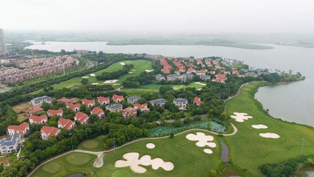 Aerial view of lakeside villa community adjacent to golf‑course green land