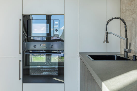 Modern Kitchen Detail with Built-In Oven, Microwave, and Sink