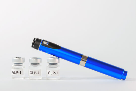 Reassuring clinical treatment shows hopeful medical weight loss injection pen device beside blue medicine vial on white surface
