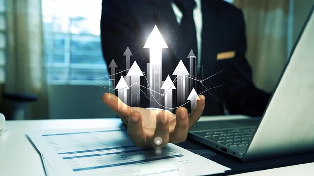 Business growth concept with upward arrows and analytics hologram, Business man working on laptop & hand holding glowing holographic arrow graph bar