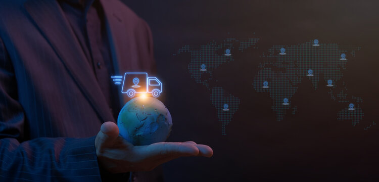 Businessman open hand supporting world globe with glowing cargo delivery truck and shipping container icons on top. Global logistics supply chain and international freight distribution concept.