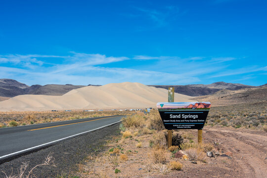 Churchill County, Nevada, United States - 11 March 2026: View of the Sand Springs Desert Study Area and Pony Express Station with sand dunes in the background under a clear blue sky.