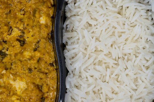 Chicken curry and rice tv dinner spicy food in plastic container flat lay closeup.	