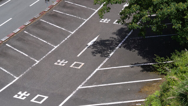 Parking vide avec marquages de sortie, lignes blanches et ombres d&rsquo;arbres