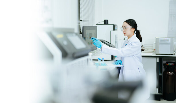 Female scientist conducting laboratory research and sample analysis using modern technology, scientific equipment and digital data