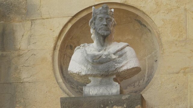 Close up view of carved stone bust sculpture wearing crown in wall niche