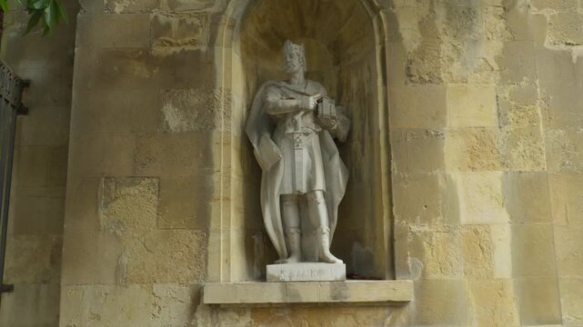 Standing crowned king sculpture inside stone niche in Oviedo Spain