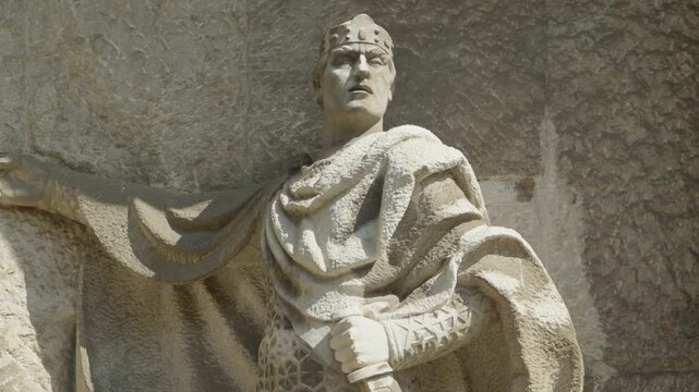 Medium shot of crowned royal figure sculpture in stone wall relief in Oviedo