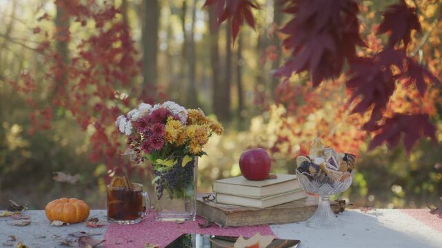 Autumn coffee moment on table. Cozy fall table with flowers. Autumn picnic table setting. Fall leaves around cozy table.
