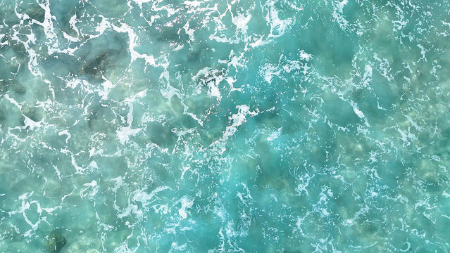 Aerial Top Down View of Turquoise Ocean Water and White Foam