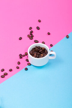 Cup with coffee beans on a colored background