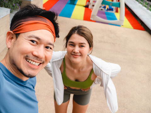 Happy Asian Couple Captures a Joyful Selfie Moment Outdoors After an Exercise Session
